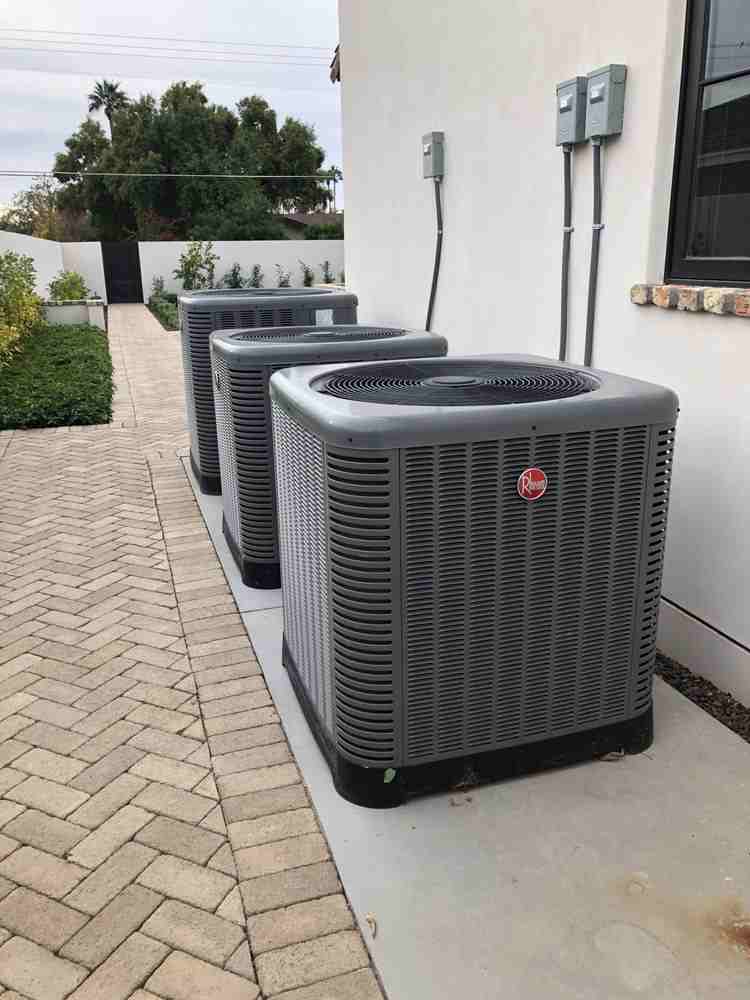Three air conditioning units stored outdoors